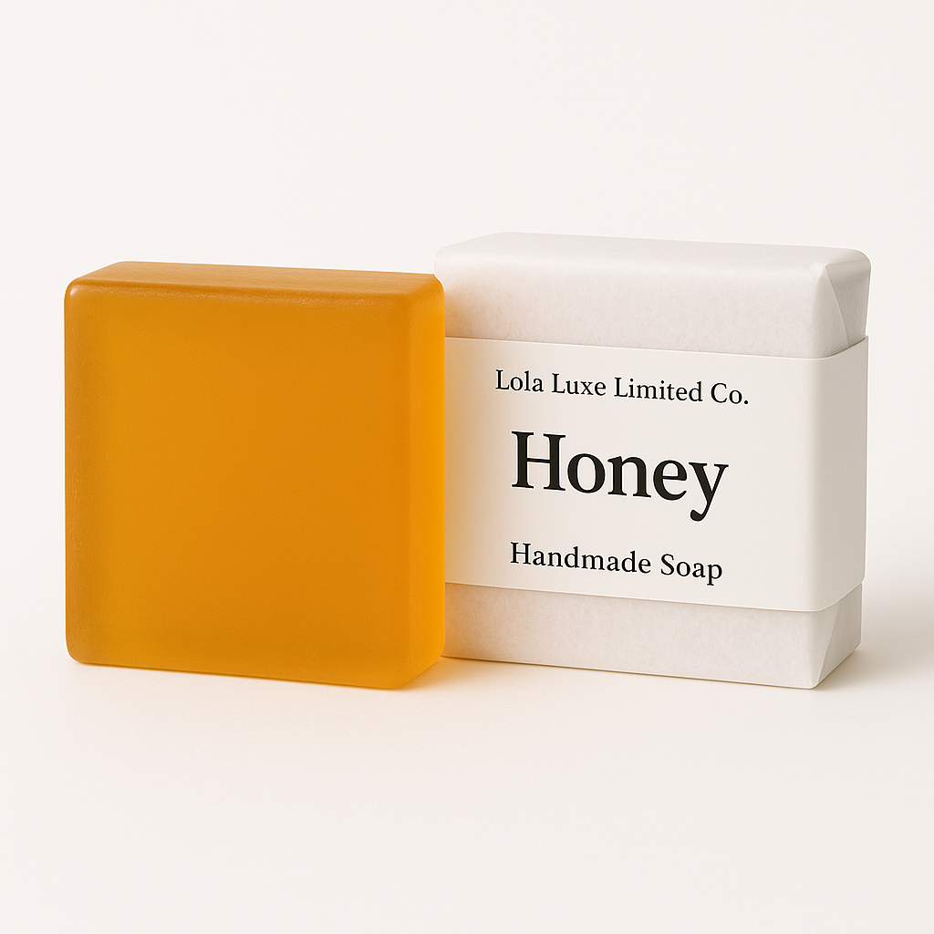 Orange handmade soap next to a white box labeled 'Honey' by Lola Luxe Limited Co. on a white background.