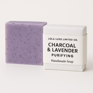 Bar of charcoal and lavender soap with packaging on a white background